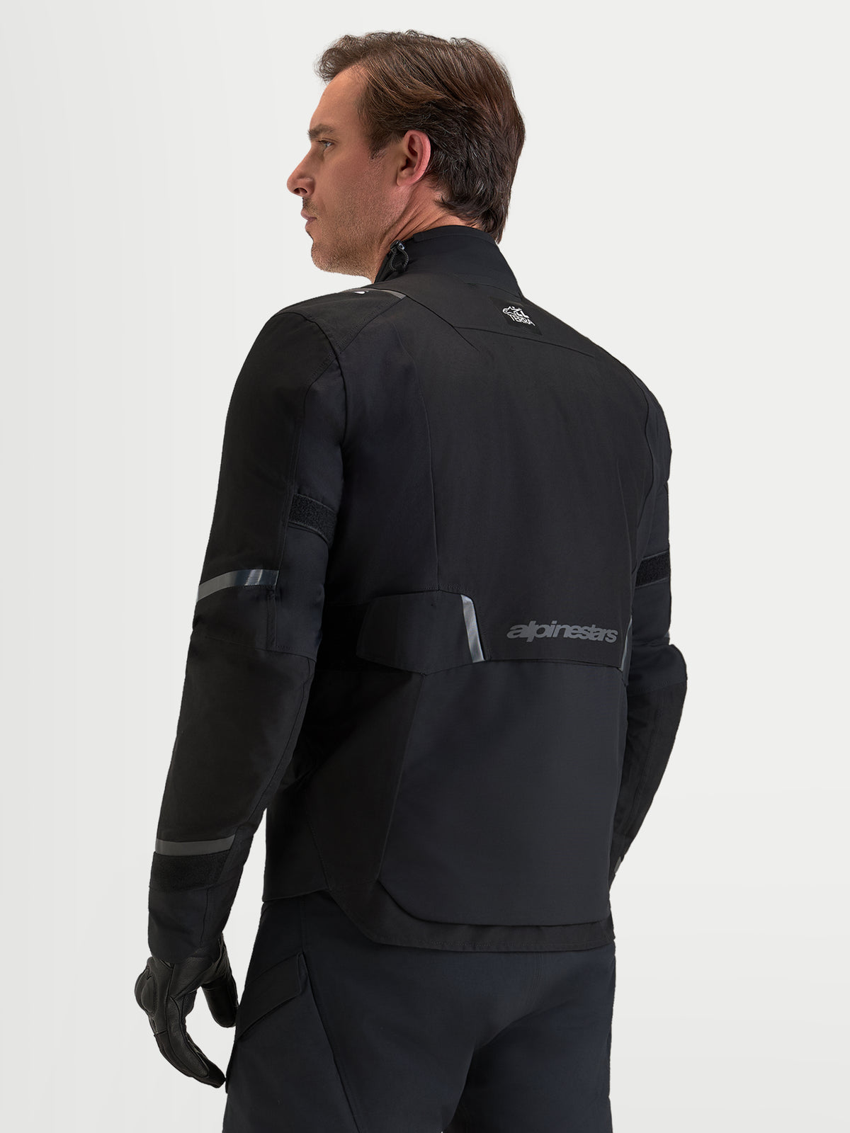 Alpinestars St-7 V2 2L Gore-Tex Jacket, Men's Adventure Touring Motorcycle Jacket in Black, featuring a rear view of the waterproof textile shell, reflective details, and Alpinestars branding
