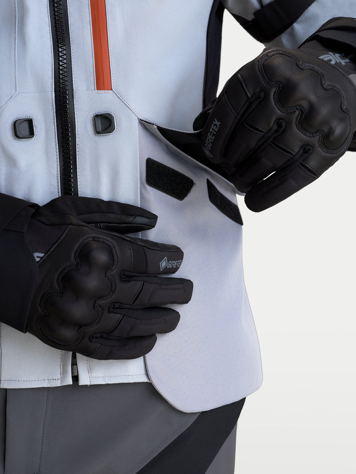 Alpinestars St-7 V2 2L Gore-Tex Jacket, Mid Gray and Black adventure motorcycle jacket, close-up view of rider opening the direct ventilation panel, featuring waterproof laminated shell and black gloves