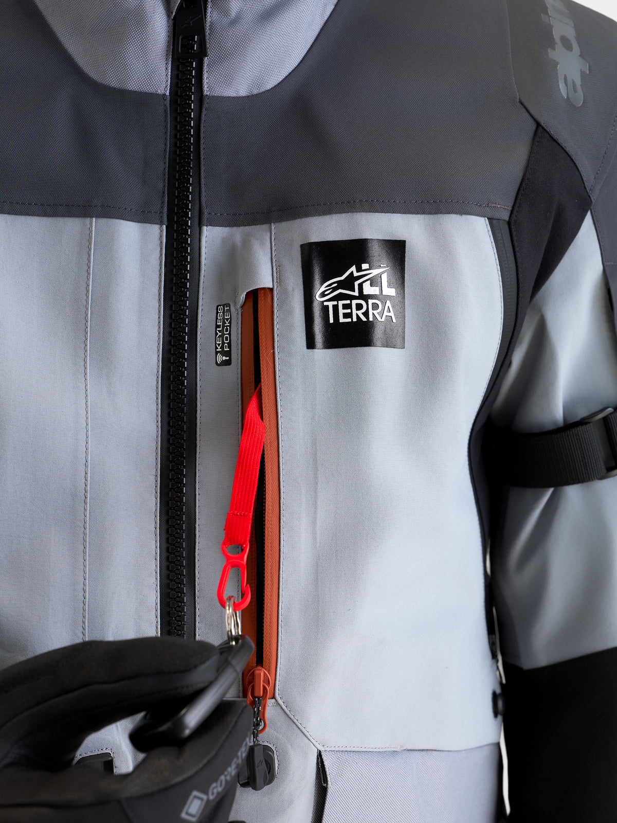 Alpinestars St-7 V2 2L Gore-Tex Jacket, Adventure Motorcycle Jacket, Mid Gray and Black, close-up view of the waterproof keyless pocket with red attachment cord and All Terra branding
