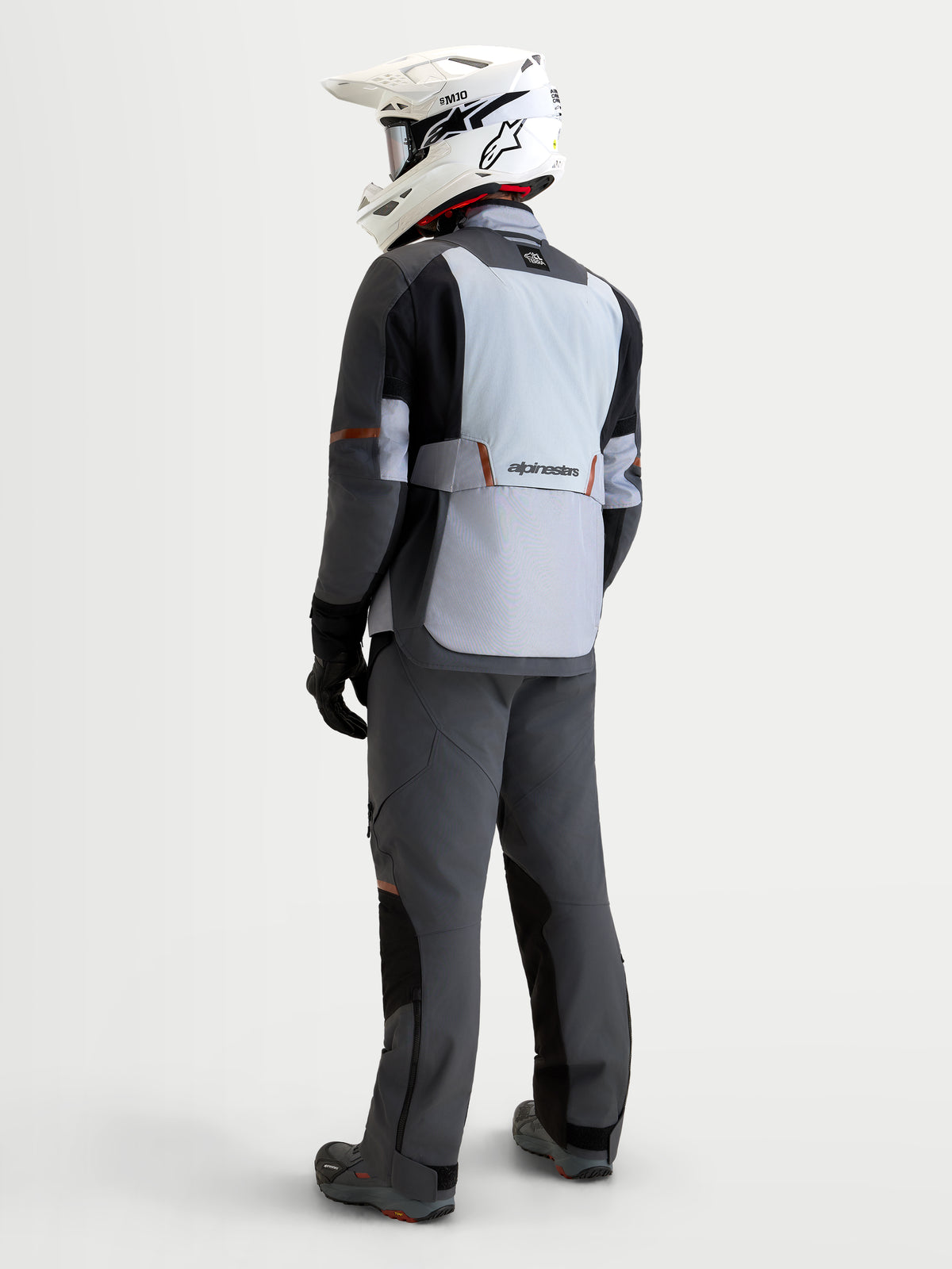 Alpinestars St-7 V2 2L Gore-Tex Jacket, men's adventure touring motorcycle jacket, mid gray, deep gray, and black, shown from the rear view on a rider wearing an off-road helmet