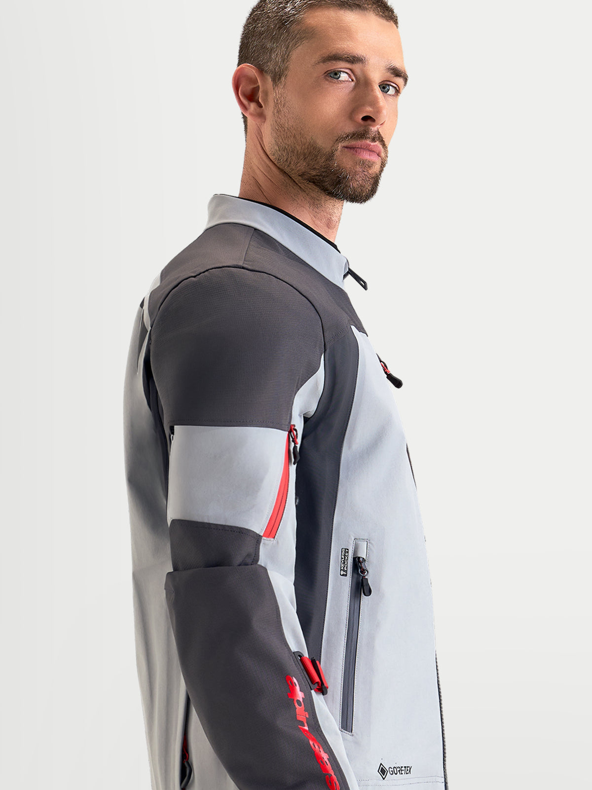 Alpinestars Arenis Gore-Tex Jacket, men's adventure touring motorcycle jacket in mid gray, deep gray, and black, side profile view showing waterproof textile construction and ergonomic collar.