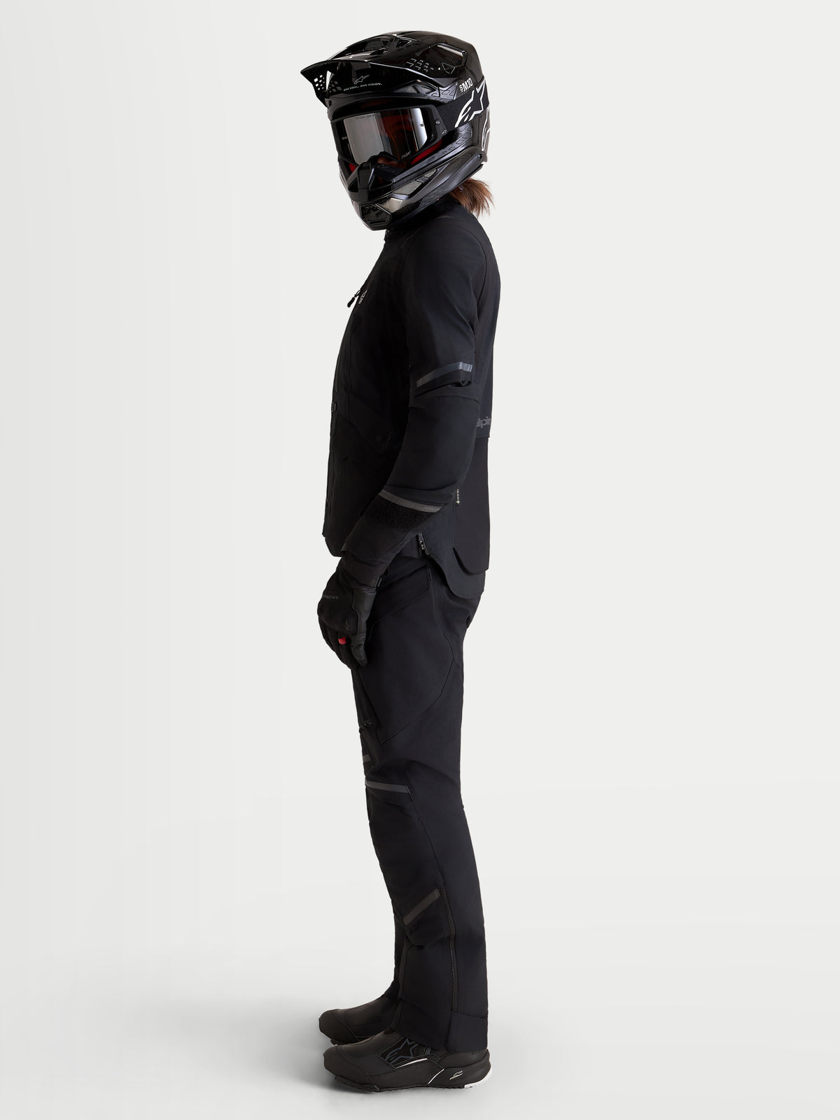 Alpinestars Stella ST-7 V2 2L GORE-TEX Jacket, women's adventure touring motorcycle jacket in black, side profile view on a model wearing matching gear and helmet, waterproof textile construction.