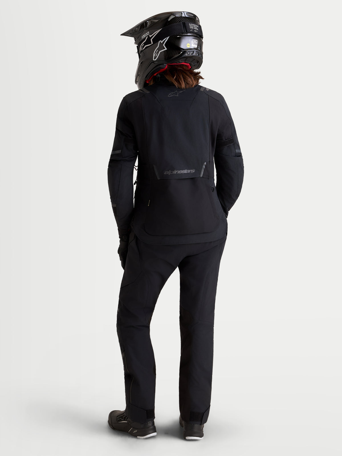 Alpinestars Stella ST-7 V2 2L Gore-Tex® Jacket, women's adventure touring motorcycle jacket in black, rear view on a model wearing matching gear and helmet, waterproof textile construction.