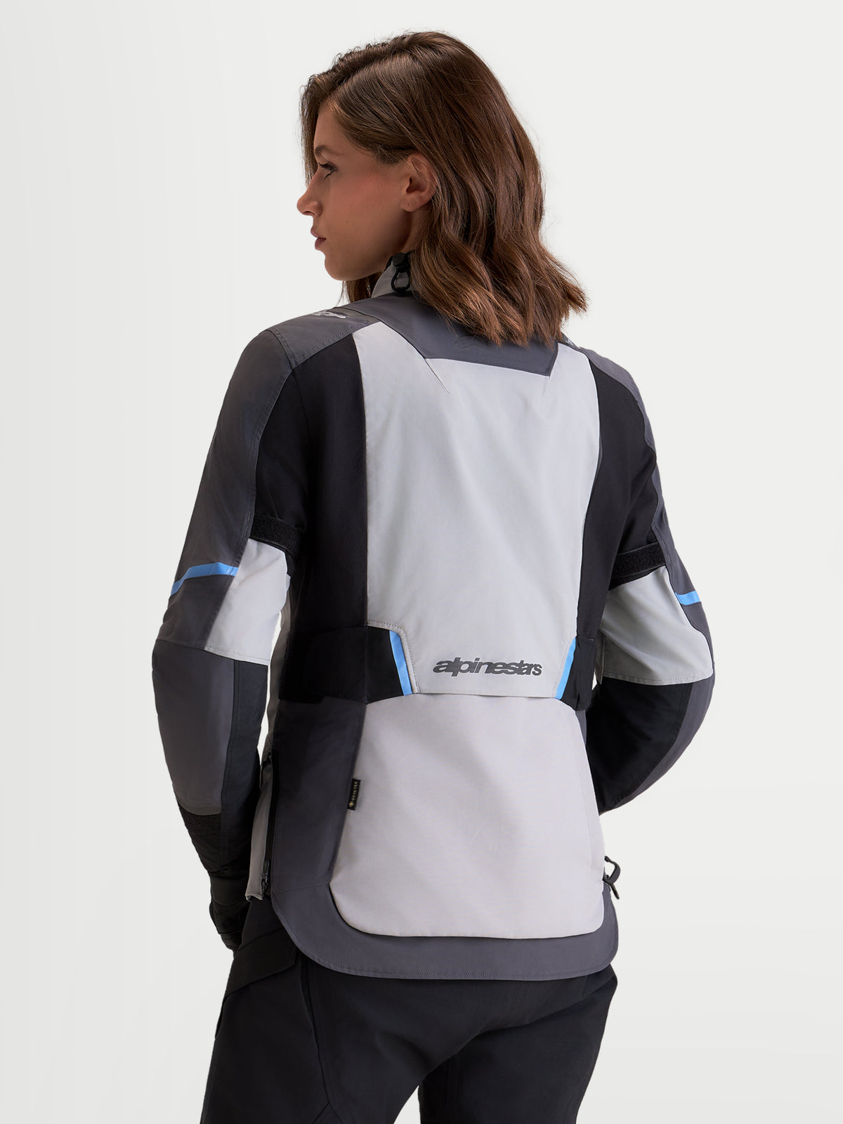 Alpinestars Stella ST-7 V2 2L Gore-Tex Jacket, women's adventure touring motorcycle jacket in mid gray, deep gray, and black, rear view showing waterproof textile construction and Alpinestars branding worn by a model.