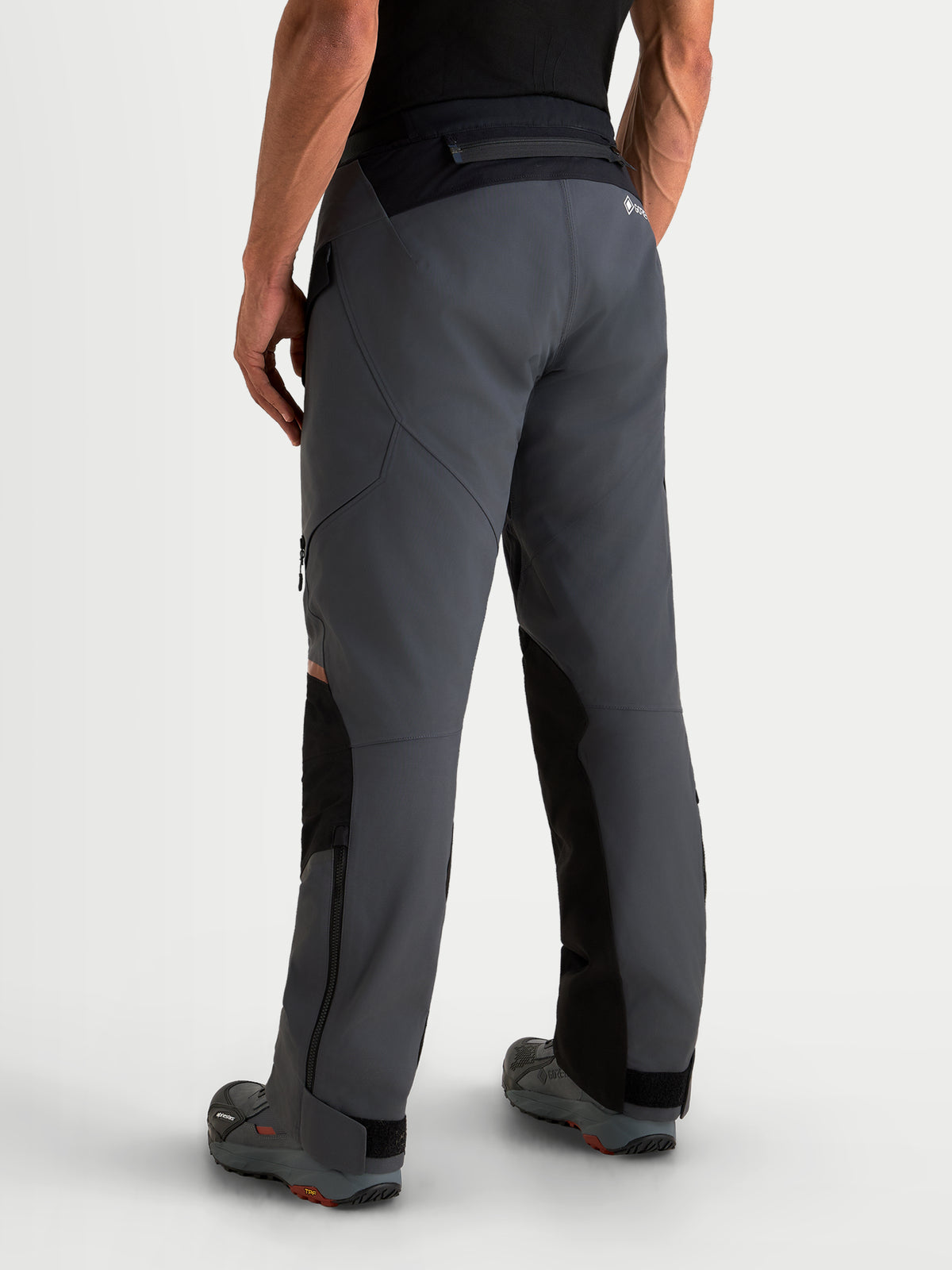 Alpinestars St-7 V2 2L Gore-Tex Pants, men's adventure touring motorcycle pants in deep gray and black, rear profile view on a model showing waterproof textile construction and reinforced seat area.