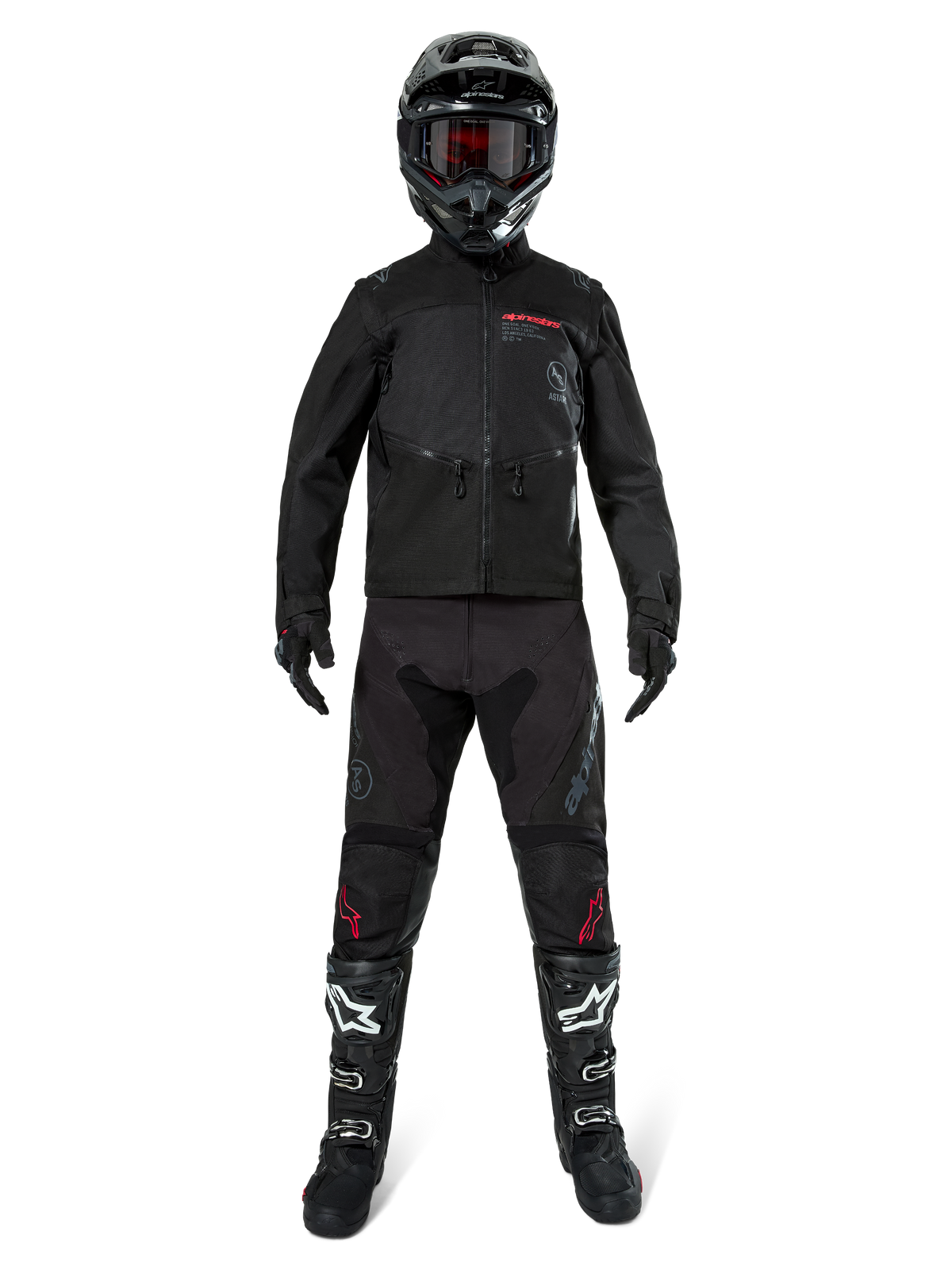 Alpinestars Pro-Dura Jacke, schwarze Offroad-Enduro-Jacke, gezeigt an einem Modell mit kompletter Ausrüstung inklusive schwarzem Helm mit roter Brille, schwarzer Hose mit roten Akzenten, schwarz-weißen Stiefeln und schwarzen Handschuhen, robustes, von Rallye-Rennen inspiriertes Design für Trail-Fahrten