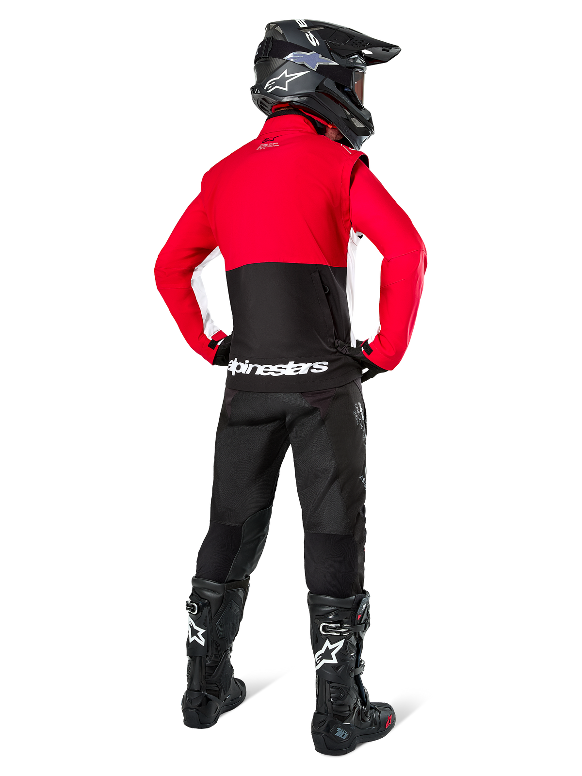 Motocross rider from behind wearing Alpinestars Lite-Dura Softshell Jacket, Black Bright Red and White, featuring a red upper panel and black lower section with white branding, paired with black pants, black helmet, and black boots, coordinated enduro outfit for off-road riding