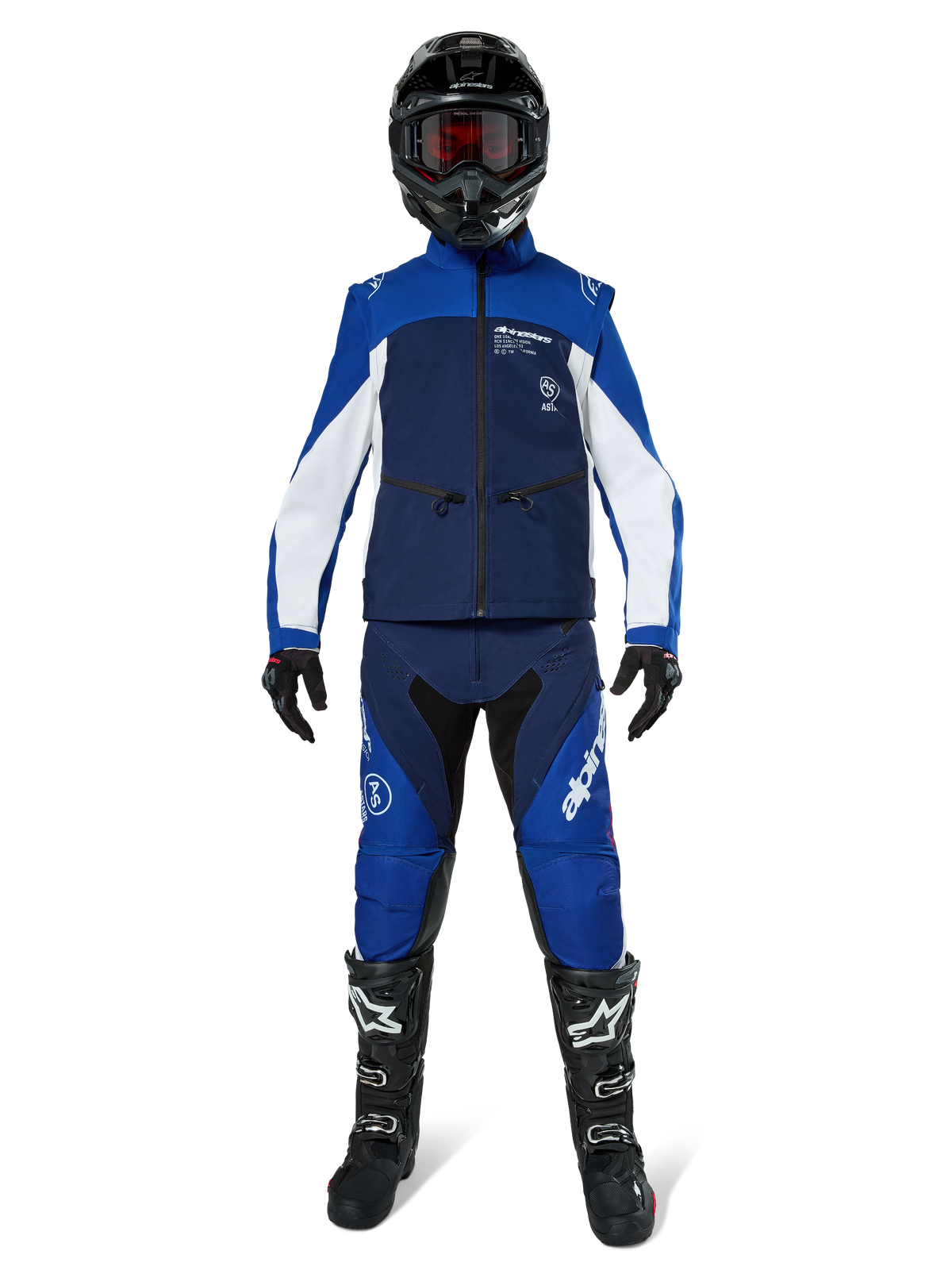 Alpinestars Lite-Dura Softshell-Jacke, Offroad-Motorradjacke in Navy, Hellblau und Weiß, getragen mit einer passenden Komplettausrüstung einschließlich schwarzem Helm, Enduro-Hose und schwarzen Stiefeln, technische winddichte Bekleidung für Dirtbike-Fahrten