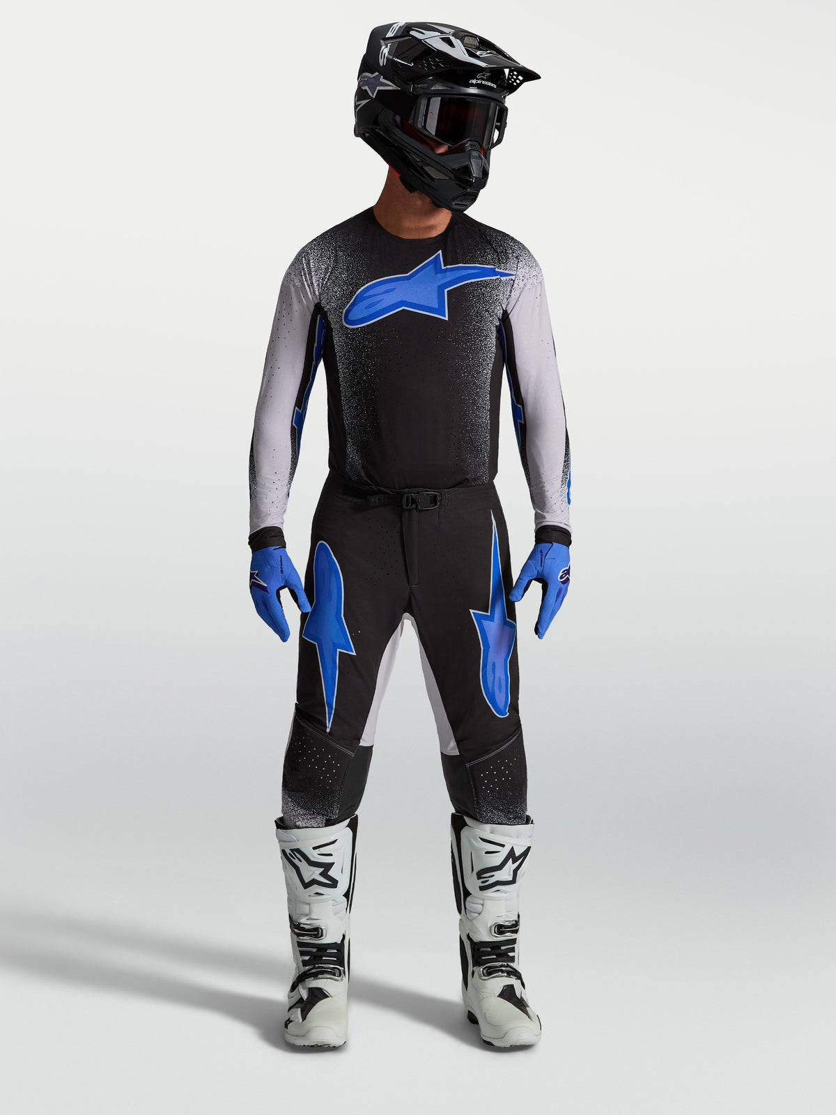 Alpinestars Supertech Hiten AFD Pants, black and blue motocross gear, on-model with matching jersey and white racing boots.