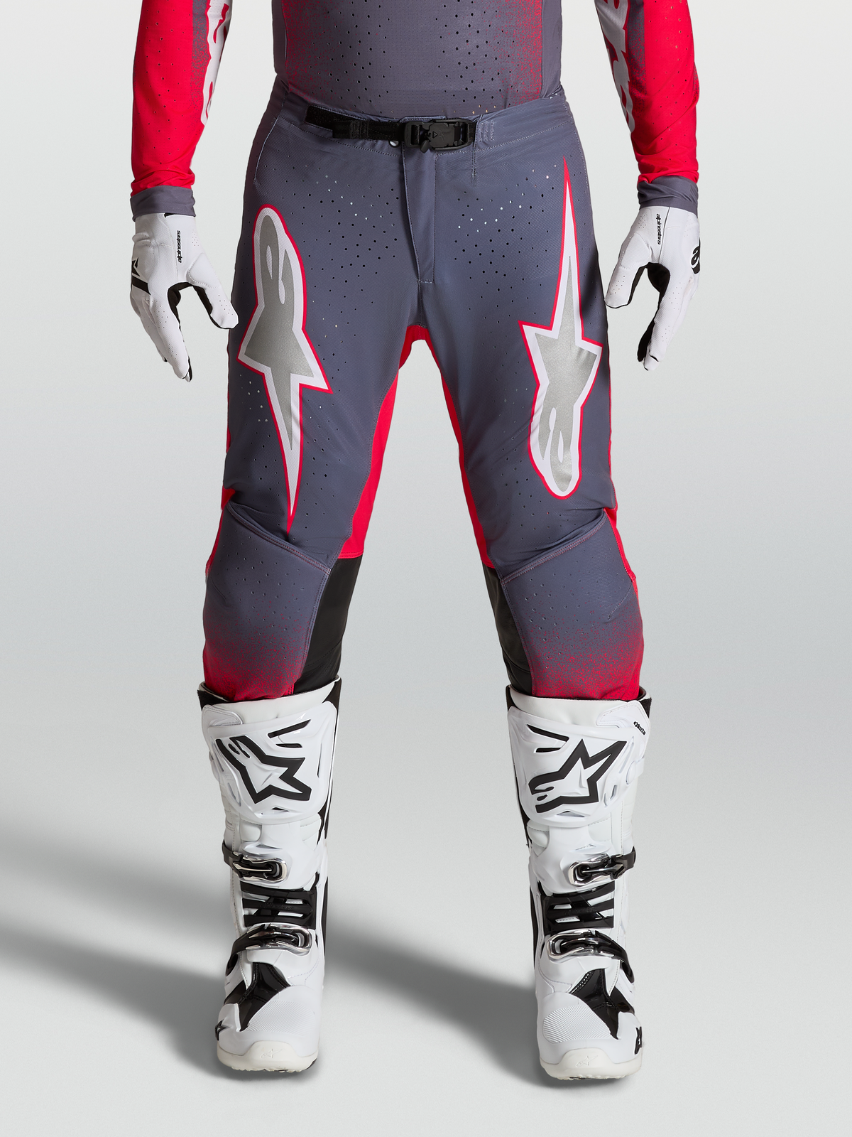 Alpinestars Supertech Hiten AFD Hose, Motocross-Hose in Grau und Rot-Fluo mit lilafarbenen Sterngrafiken, perforierte Stretch-Paneele, athletische Passform.