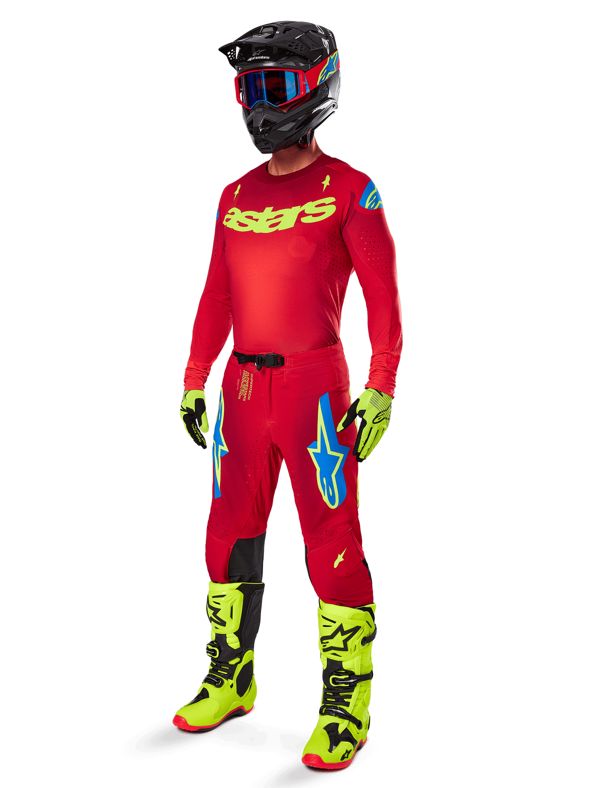 Motocross-Fahrer in kompletter Alpinestars Rennbekleidung, 2025 Supertech Maker Hose in Bright Red und Yellow Fluo, passendes rotes Trikot mit neongelbem Logo, neongelbe und schwarze Stiefel, schwarzer Helm mit blauer Brille, professionelles Outfit für den Offroad-Rennsport