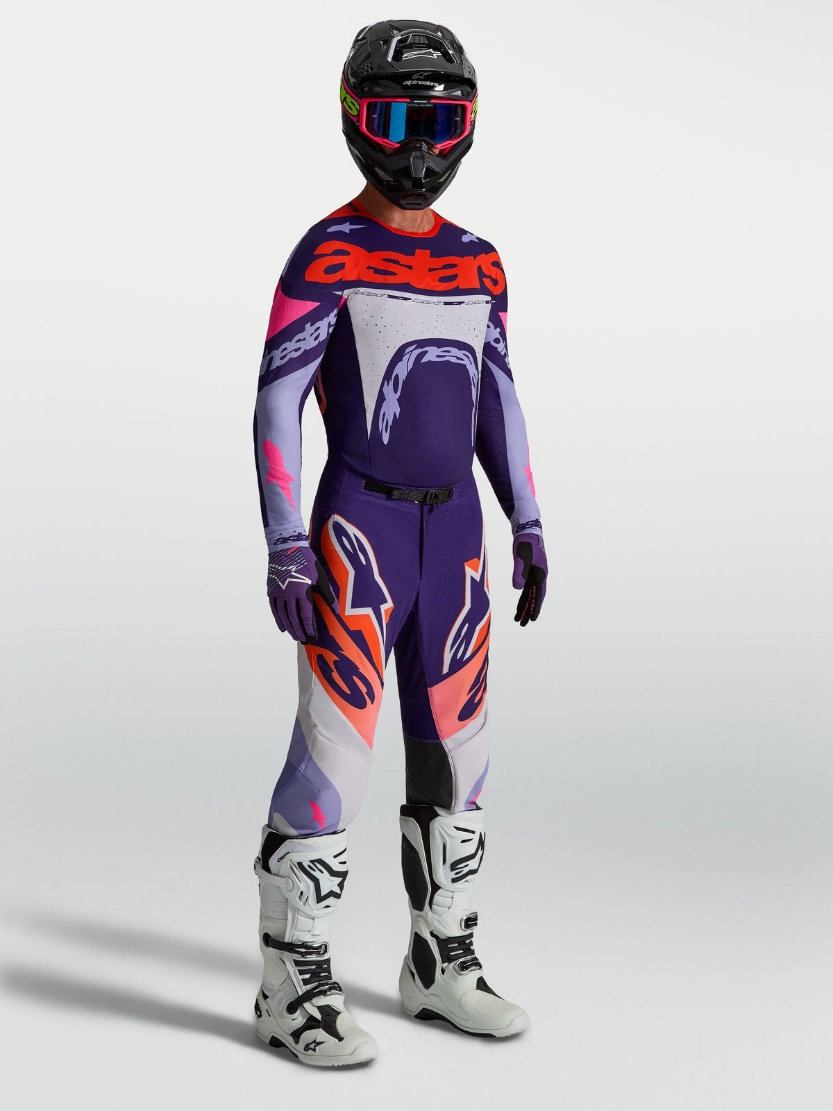 Alpinestars Supertech Dyna Hose für Herren, Lila und Pink Fluo, MX-Hose mit passendem Trikot und weißen Motorradstiefeln.