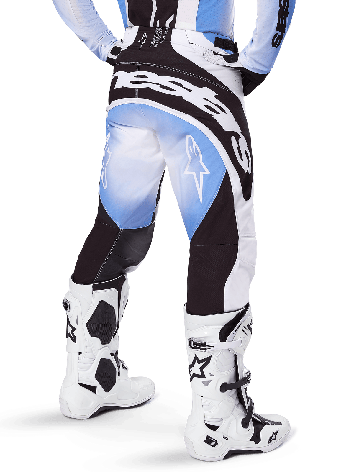 Alpinestars 2025 Techstar Melt Pants, Motocross Pants, Black Blue and White, rear view featuring bold Alpinestars wordmark across the seat and star logos on the legs, worn with white and black Tech 10 boots, professional off-road racing gear