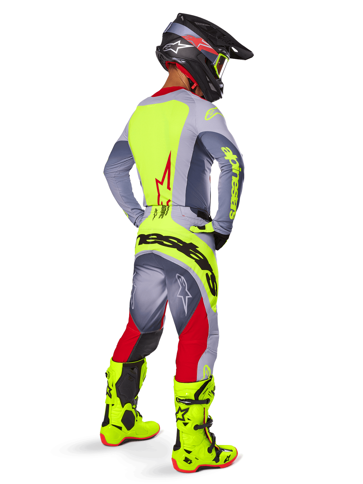 Motocross rider from a rear three-quarter view wearing Alpinestars 2025 Techstar Melt Pants in Bright Red and Gray, featuring a bold neon yellow logo across the seat, matching gray and neon yellow jersey, bright neon yellow boots, and a black helmet with neon goggles, professional off-road racing gear set.