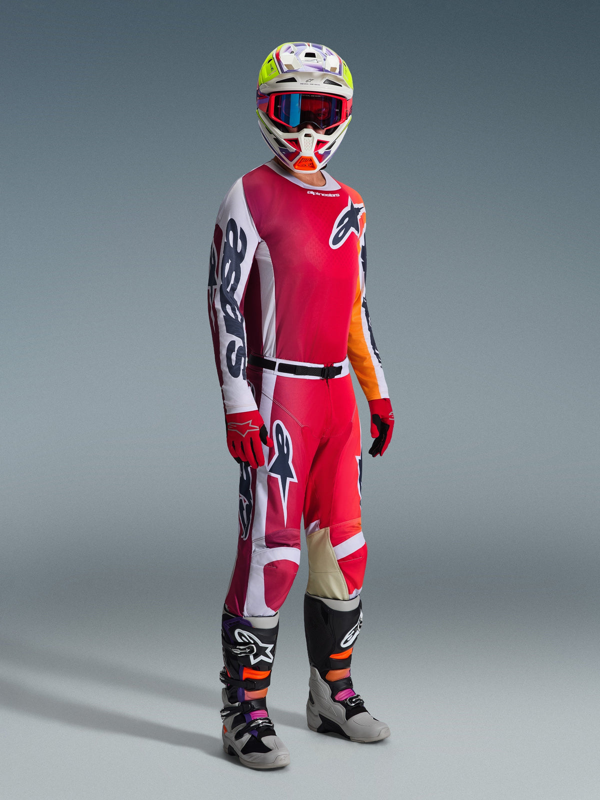 Alpinestars 2026 Racer Portl Hose, Motocross-Hose, Rot, Hellgrau und Dunkelgrau, getragen als Teil einer kompletten Rennausrüstung mit passendem Jersey, roten Handschuhen, buntem Helm mit blauer Brille und grauen Stiefeln, strapazierfähige Konstruktion für Offroad-Motocross-Performance.