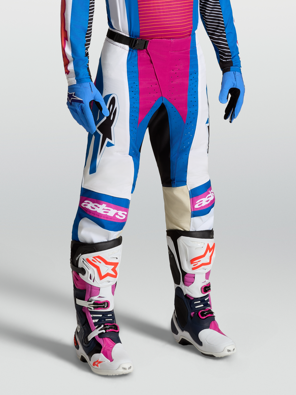 Alpinestars Techstar Maven Hose, Motocross-Hose für Herren, Weiß und Hot Coral mit Blithe Blue Akzenten, getragen von einem Model mit passenden Handschuhen und Stiefeln, professionelle Cross-Ausrüstung