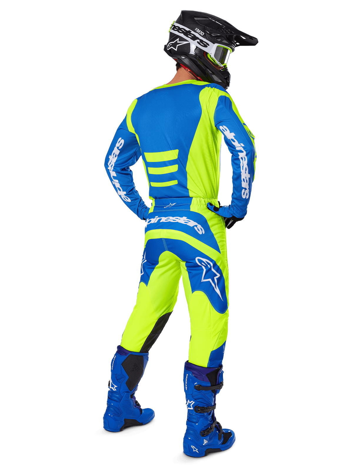 Motocross-Fahrer von hinten in Alpinestars 2025 Fluid Haul Hose und passendem Trikot in Gelb Fluo und Blau, kombiniert mit blauen Stiefeln und einem schwarzen Alpinestars-Helm, professionelle Offroad-Rennausrüstung