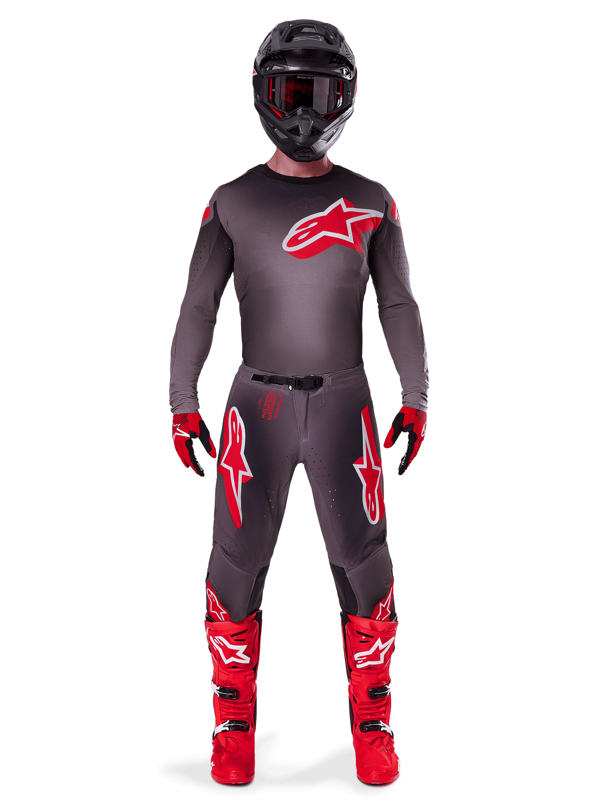 Motocross-Fahrer im kompletten Alpinestars 2025 Supertech Lipan Gear-Set, Smoke Bright Red, mit dunkelgrauem Trikot und Hose mit markanten roten Logos, schwarzem Helm mit Brille, rot-schwarzen Handschuhen und leuchtend roten Motocross-Stiefeln, professionell abgestimmtes Rennoutfit