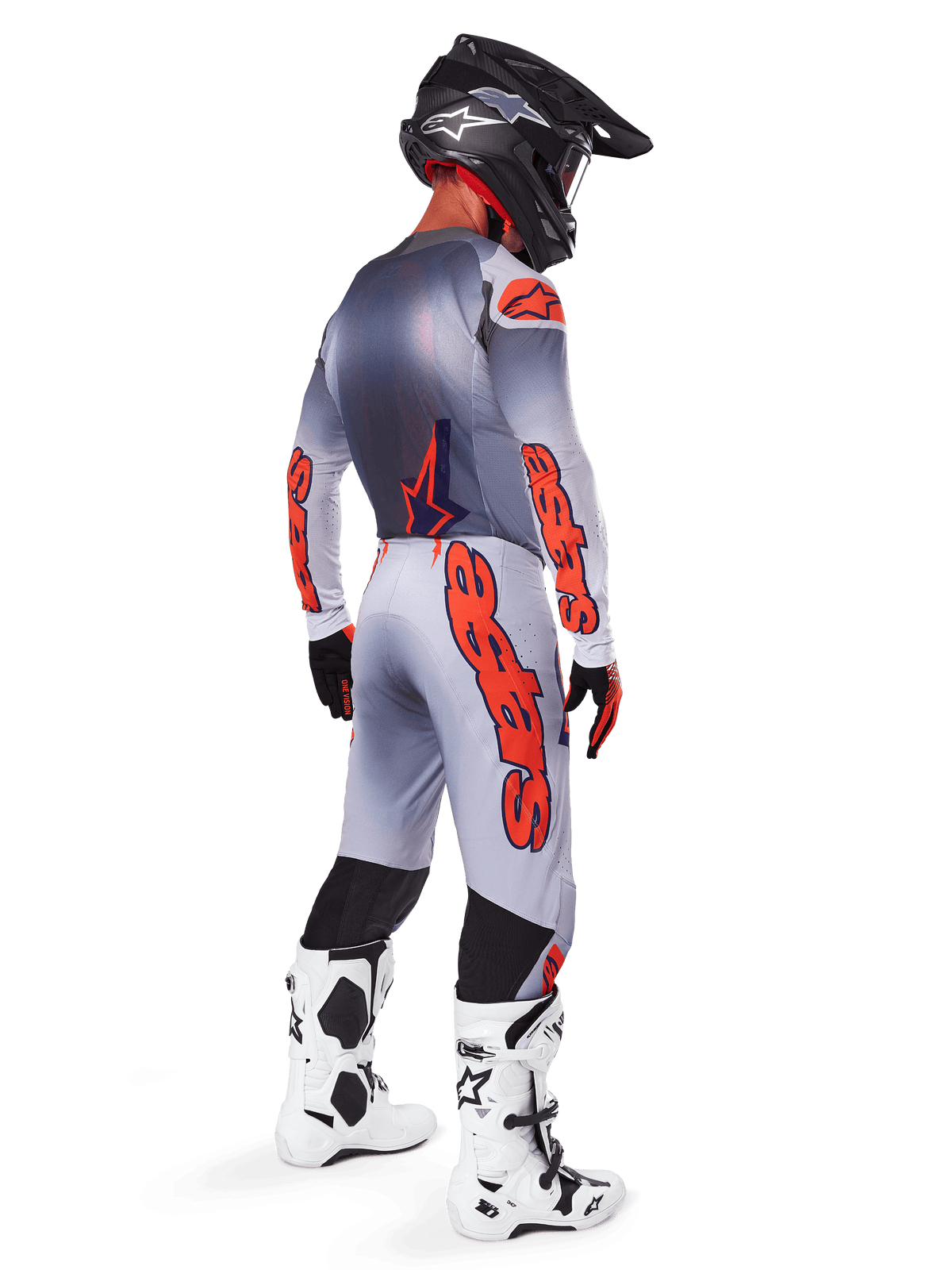 Alpinestars 2025 Supertech Lipan Hose in Grau und Orange Fluo, Motocross-Fahrer in der Rückansicht, passendes langärmliges Trikot, schwarzer Helm und weiß-schwarze Tech-Stiefel, komplette professionelle Offroad-Rennausrüstung