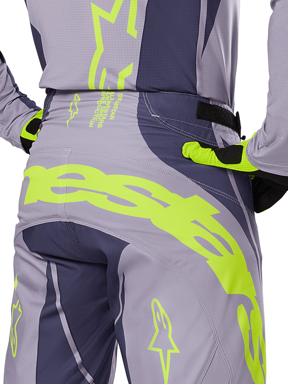 Alpinestars 2025 Techstar Dreem Hose, Motocross-Hose, Grau und Dunkelgrau mit neongelben Akzenten, Rückansicht mit markantem Alpinestars-Branding auf der Passe, getragen mit passendem Trikot und Handschuhen, entwickelt für den Offroad-Rennsport.