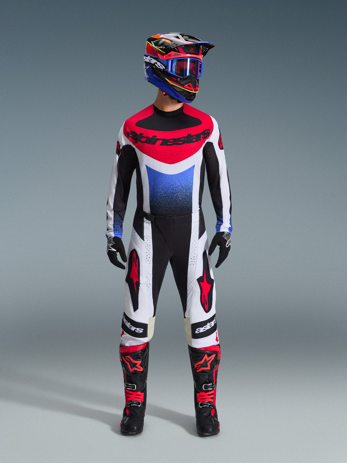 Alpinestars 2026 Techstar Knif Hose, Motocross-Hose, Schwarz, Weiß und Rot, getragen als Teil einer kompletten Rennausrüstung mit passendem Jersey und Helm, mit roten Stern-Logos auf den Oberschenkeln und einer schlanken, athletischen Passform für den Offroad-Rennsport.