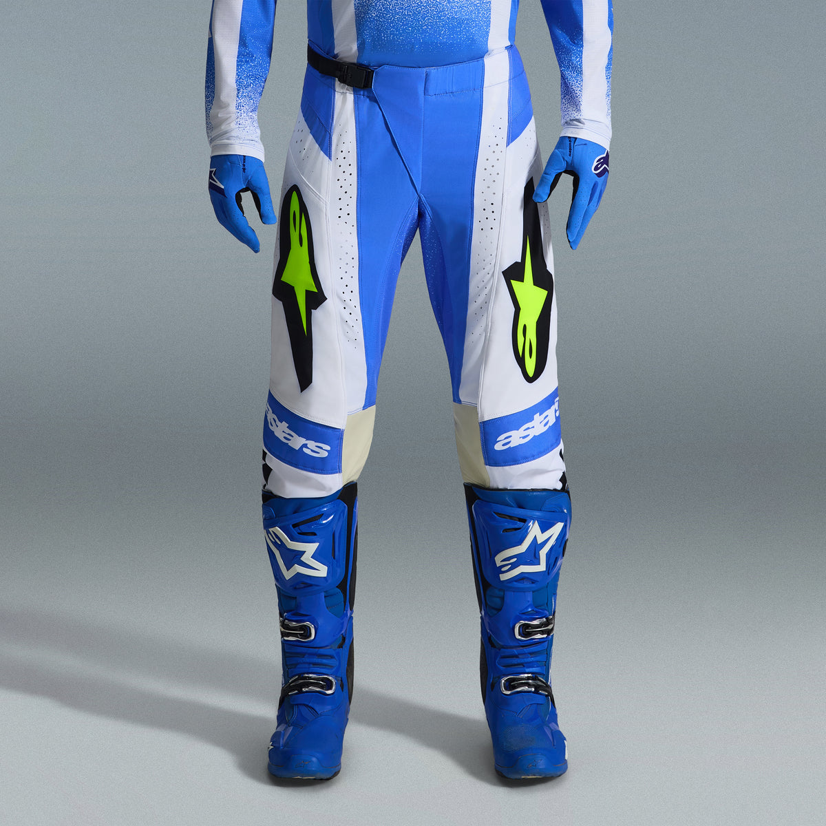 Alpinestars 2026 Techstar Knif Gear Set, Blue and White Motocross Pants with fluorescent yellow logos, matching blue boots and gloves, professional athletic racing outfit for off-road competition
