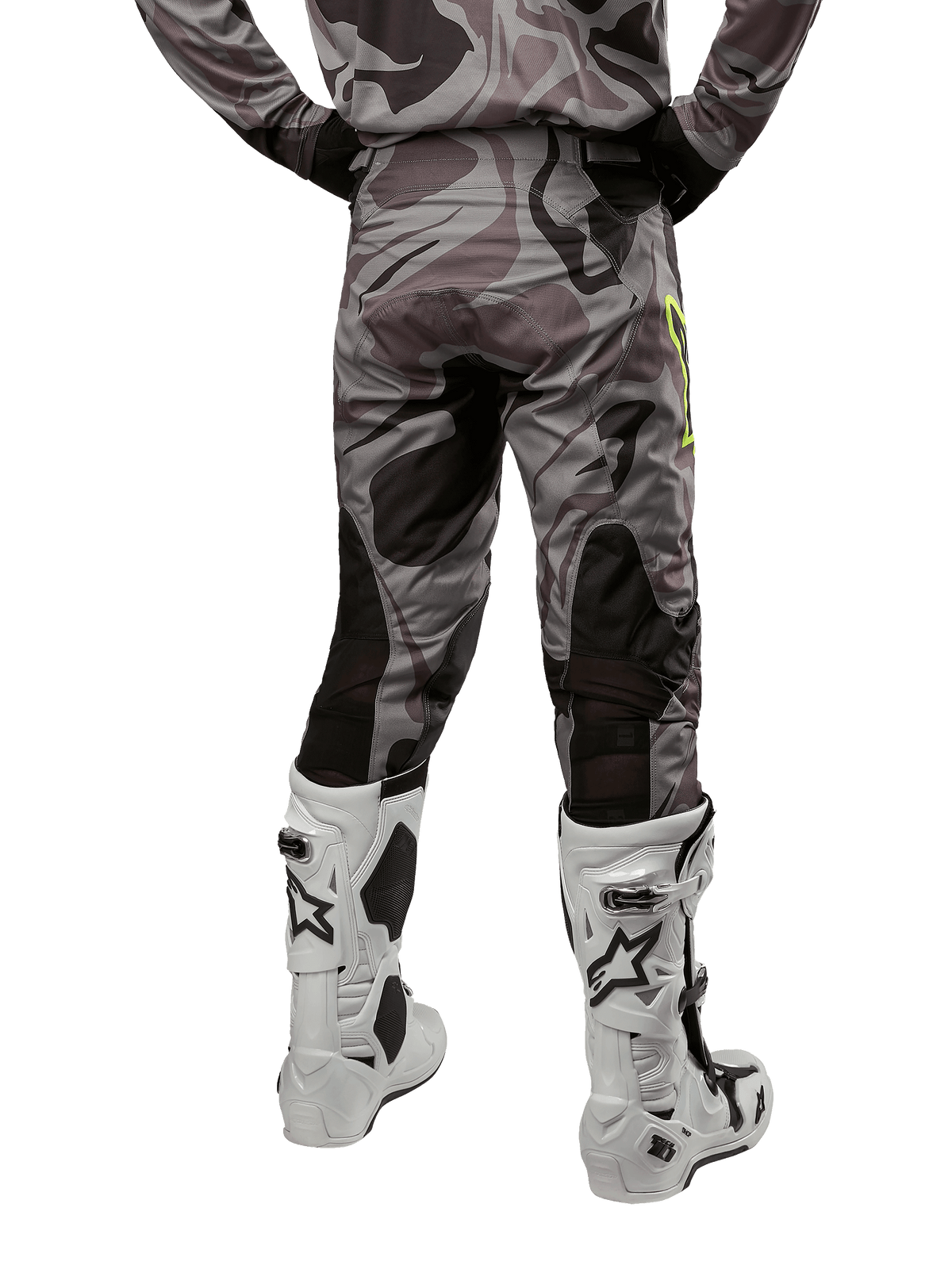 Alpinestars 2024 Racer Tactical Hose, Motocross-Hose, Cast Gray Camo Magnet, Rückansicht zeigt Camouflage-Muster und schwarze atmungsaktive Stretch-Zonen, getragen mit weiß-schwarzen Motocross-Stiefeln, entwickelt für Offroad-Rennsport.