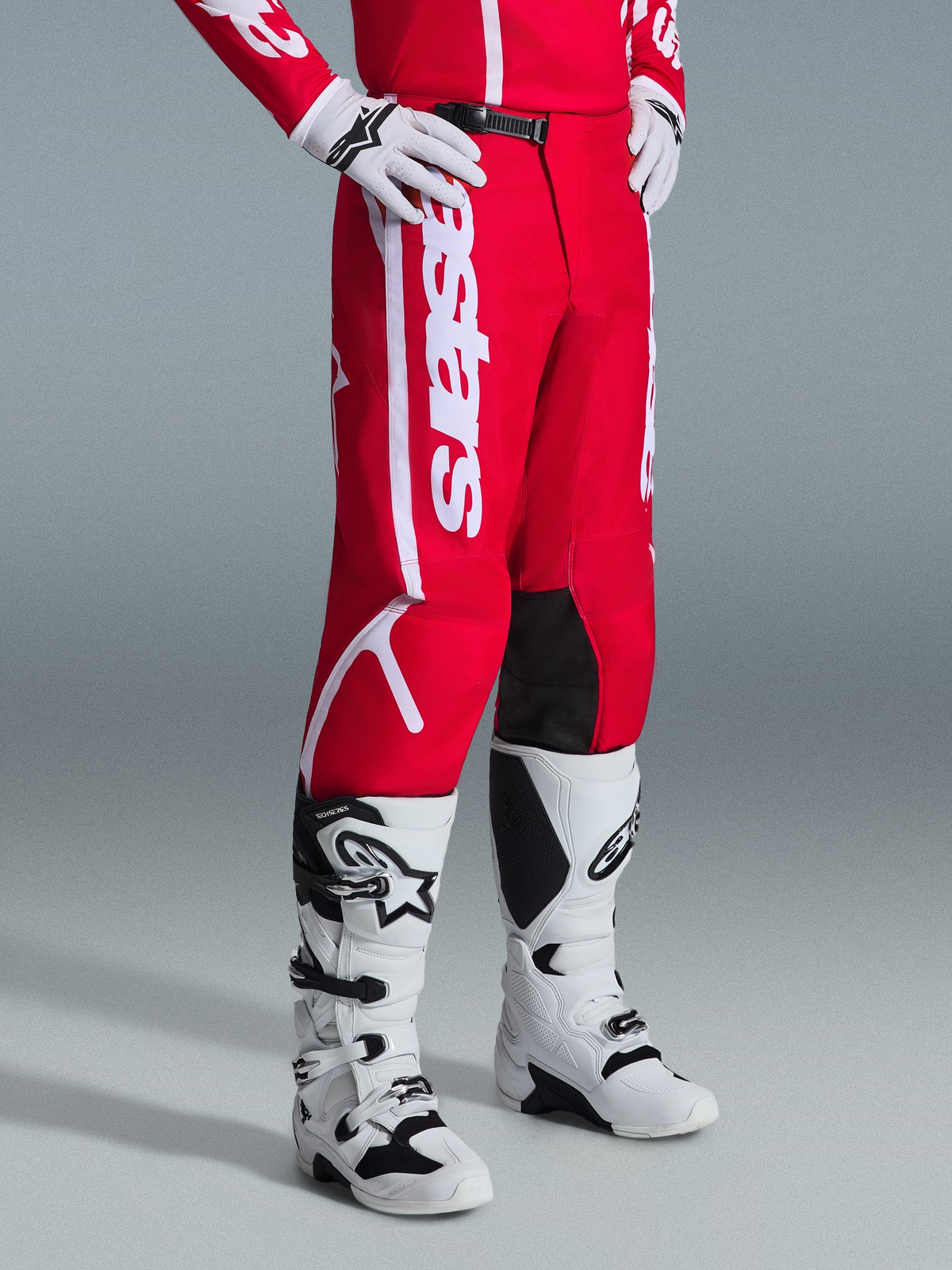 Alpinestars 2026 Fluid Apex Pants, Motocross Pants, Red and White, worn with white and black motocross boots and gloves, featuring bold white branding and black inner knee panels, designed for off-road performance