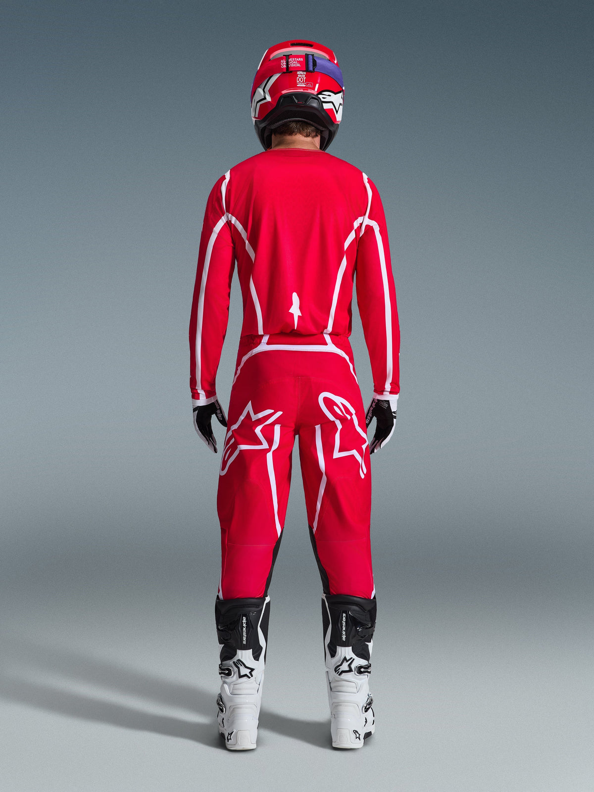 Alpinestars 2026 Fluid Apex Pants, Motocross Pants, Red and White, rear view worn with matching jersey, red helmet, and white and black boots, featuring large white Astar logos on the legs, coordinated outfit for off-road racing