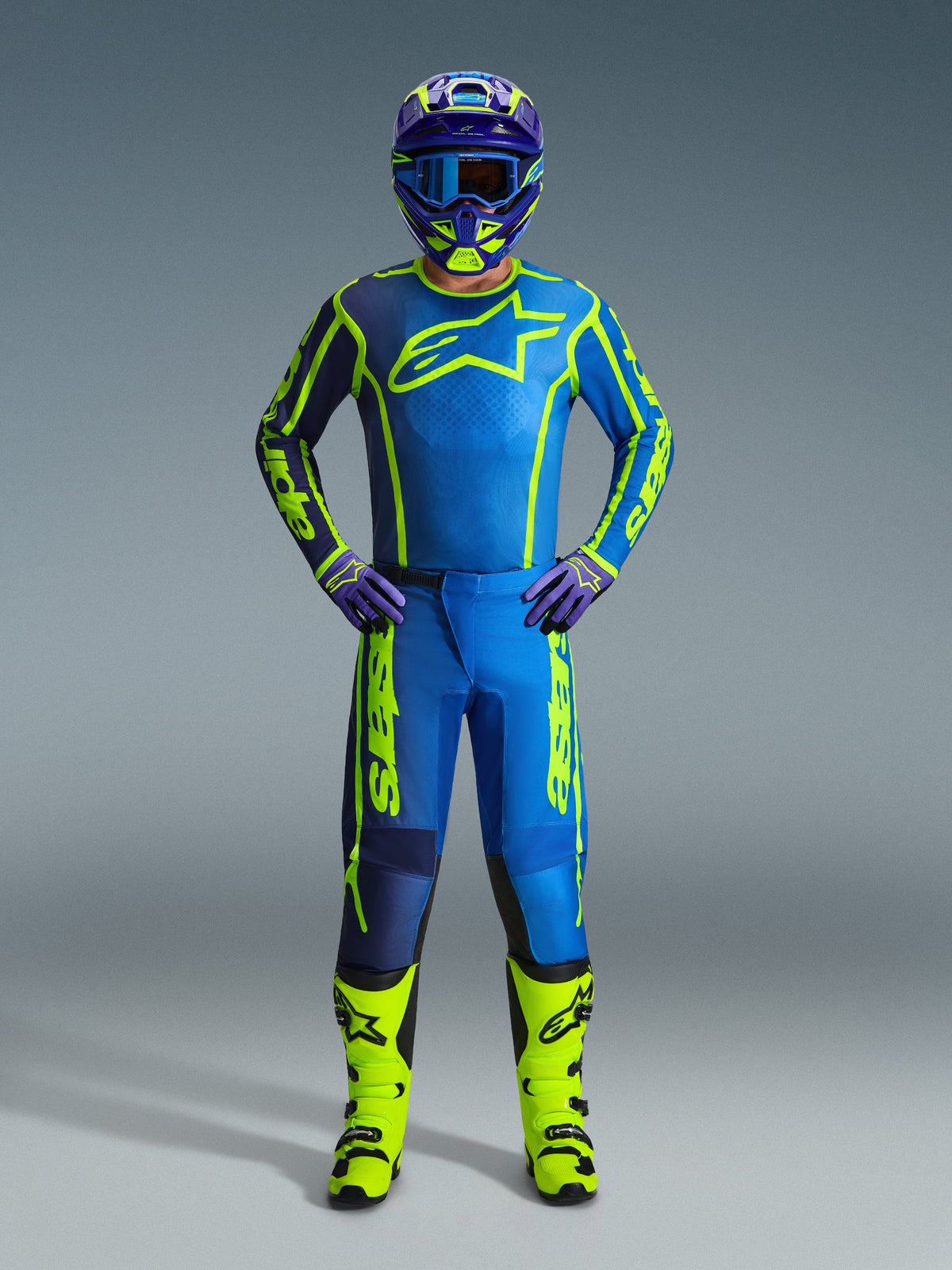 Alpinestars 2026 Fluid Apex Pants, Motocross Pants, Blue and Yellow Fluo, worn by a rider with matching jersey, helmet, gloves, and boots, featuring bold yellow Alpinestars branding on a blue base, coordinated off-road racing outfit