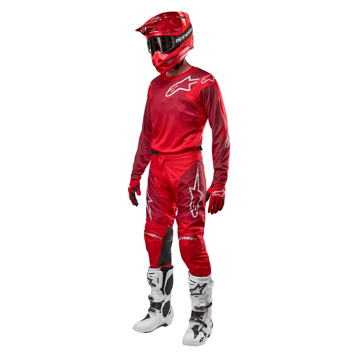 Motocross rider wearing complete racing gear, Alpinestars 2024 Racer Hoen Pants and jersey in Mars Red Burgundy, red helmet, red gloves, and white and black boots, coordinated outfit for off-road racing