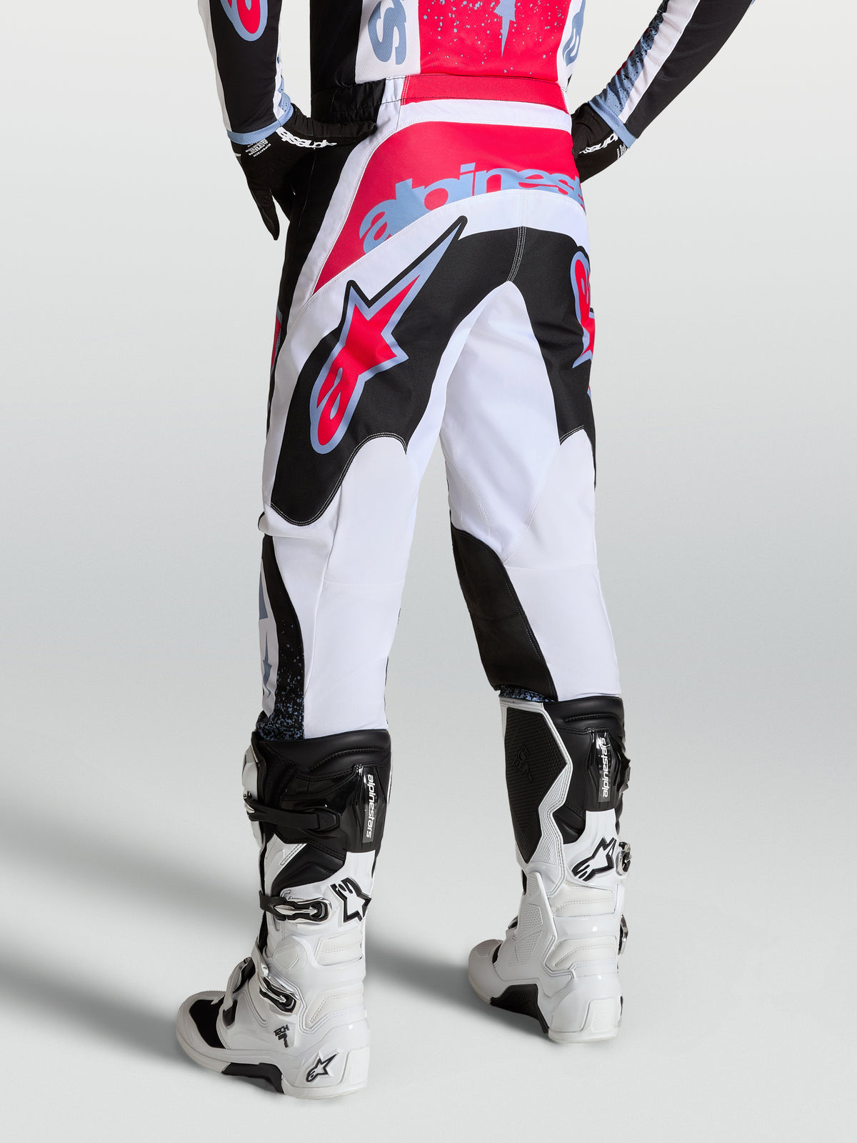 Alpinestars Fluid Drag Hose, Herren-Motocross-Hose in Weiß und Schwarz mit roten und hellblauen Akzenten, Rückansicht.