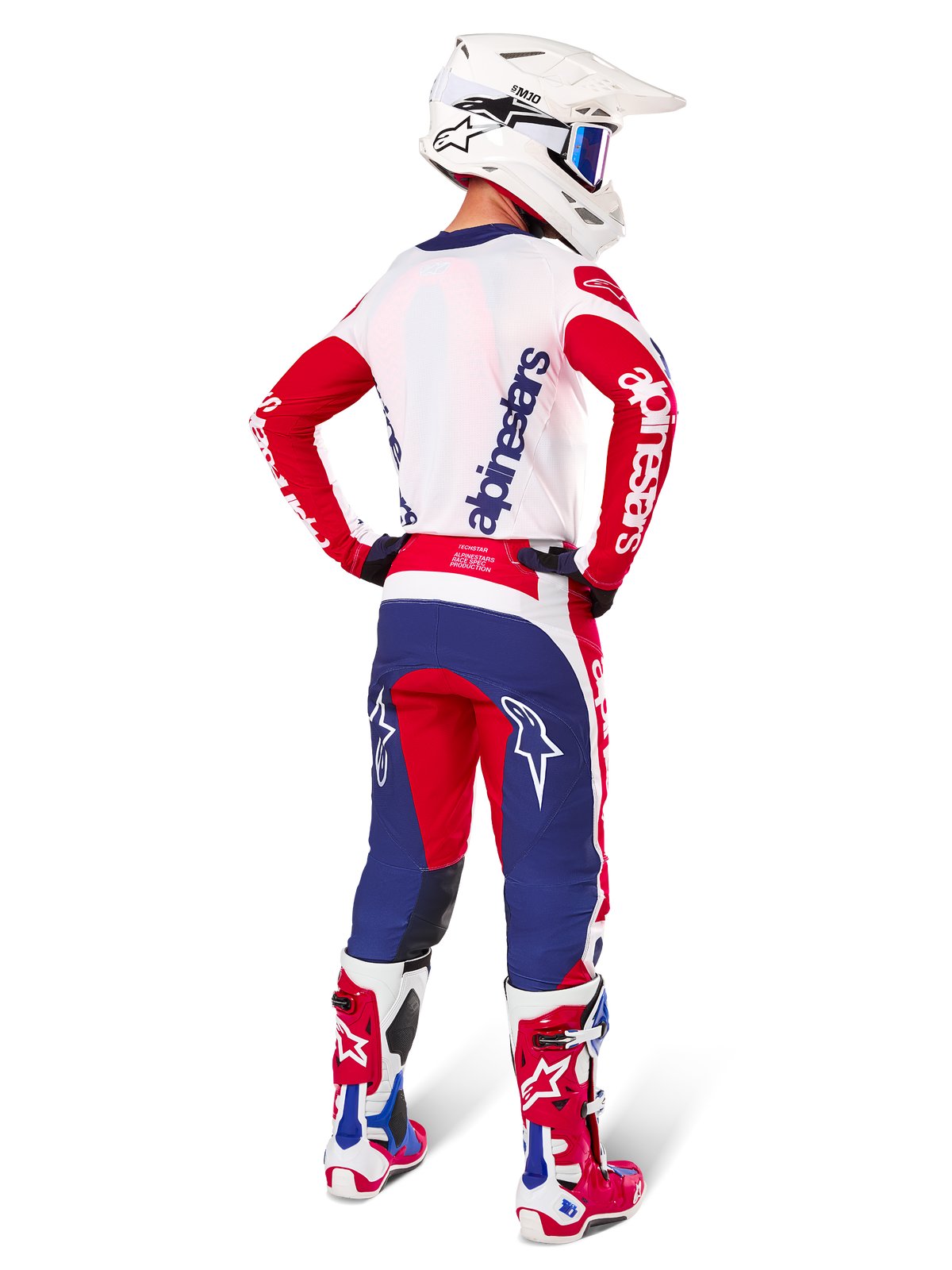 Alpinestars Limited Edition Techstar Fortitude Hose, Motocross-Hose, Hellrot, Weiß und Blau, in der Rückenansicht an einem Fahrer mit passendem Trikot, Stiefeln und Helm dargestellt, hebt die athletische Passform und die markante Logoplatzierung hervor.