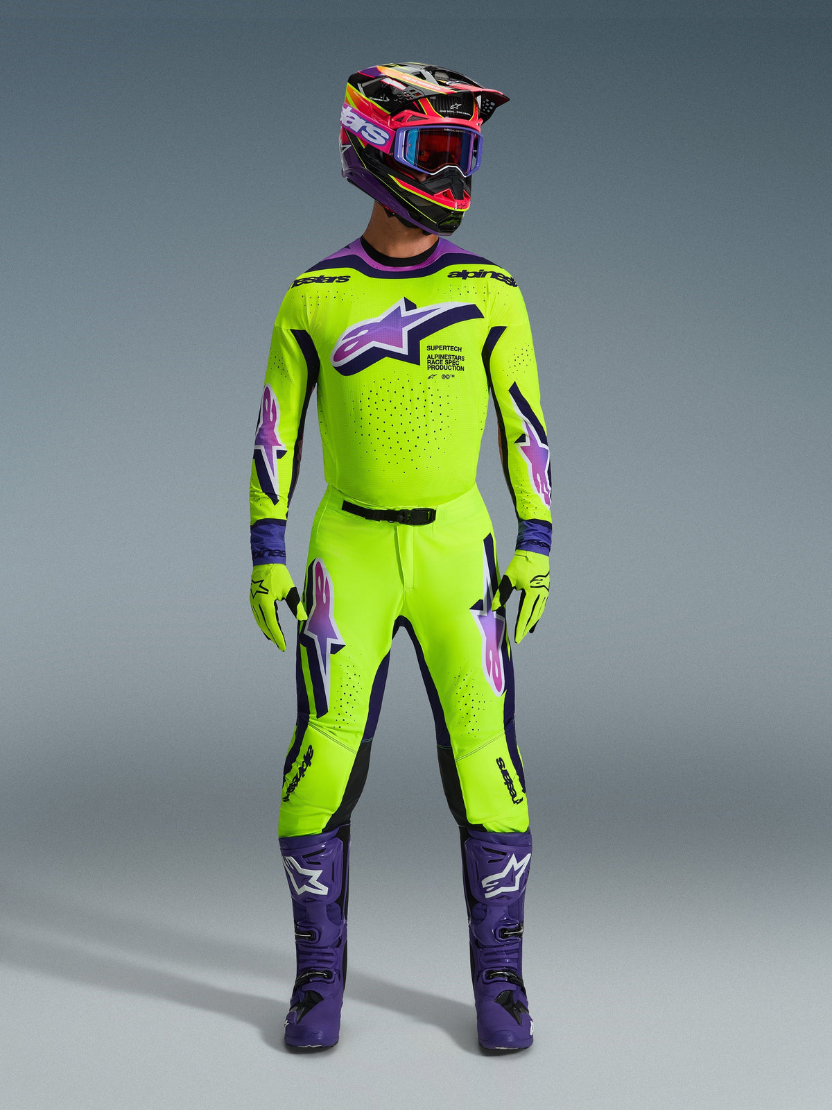 Alpinestars 2026 Supertech Vista Pants, Motocross Pants, Neon Yellow with Purple and Black accents, worn as part of a coordinated racing gear set with matching jersey, helmet, and purple boots, featuring a professional athletic fit and bold logos for off-road performance
