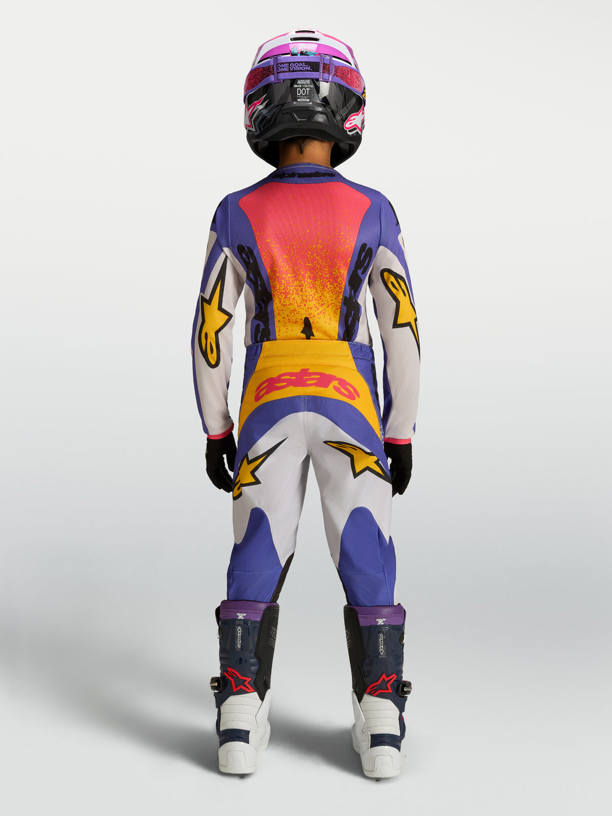 Alpinestars Fluid Drag Jugend-Hose, Motocross-Hose in Blau und Weiß mit gelben Akzenten, Rückansicht in voller Offroad-Montur.