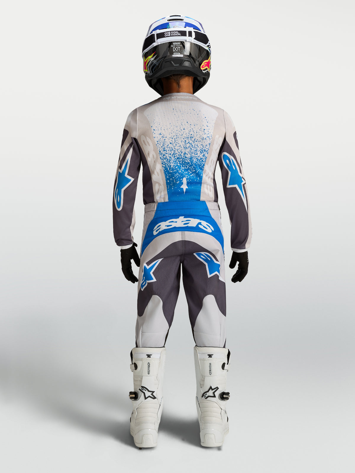 Alpinestars Fluid Drag Jugend-Hose 2027, Motocross-Hose für Kinder, Grau und Blau, Rückansicht mit Trikot und weißen Stiefeln.