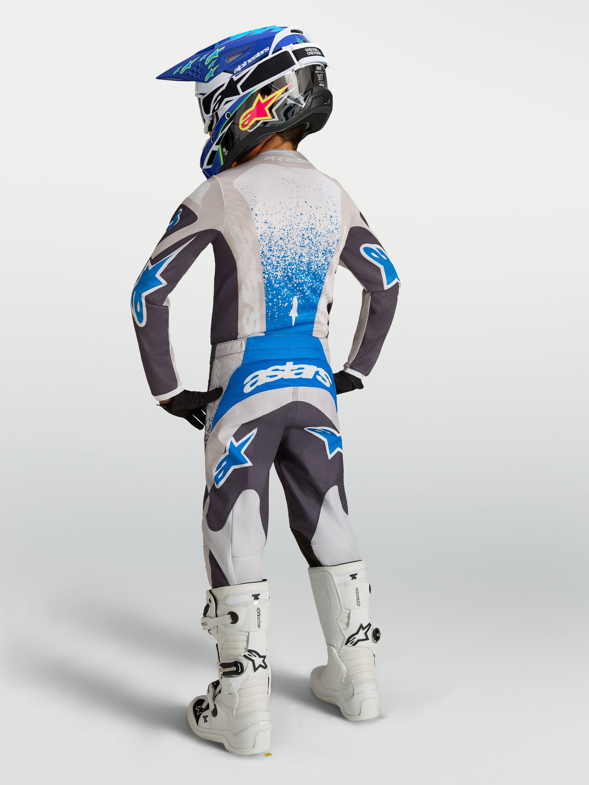 Alpinestars Fluid Drag Jugend-Hose, Motocross-Hose in Grau und Blau, Rückansicht eines jungen Fahrers, 600D-Polygewebe.