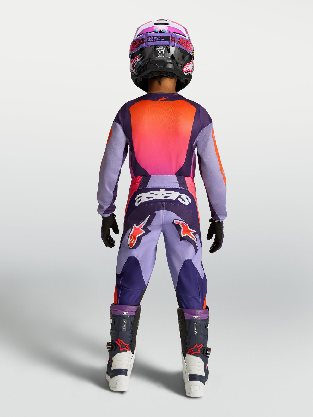 Alpinestars Fluid Hunt Jugend-Hose in Lila und Pink, Motocross-Hose für Kinder, Rückansicht am Modell mit Rennausrüstung.