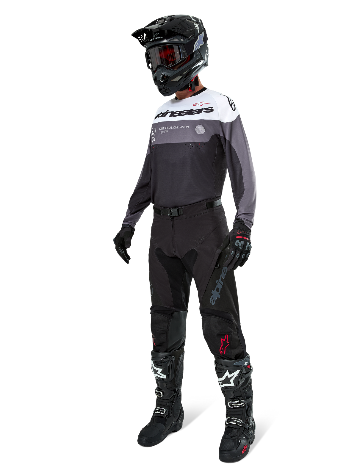Alpinestars Pro-Dura Trikot in Black Magnet White, Motocross-Fahrer in voller Ausrüstung mit schwarzer Hose, schwarzem Helm mit Brille und schwarz-weißen Stiefeln, technisches Color-Block-Design mit weißen, grauen und schwarzen Paneelen, entwickelt für Enduro- und Offroad-Performance