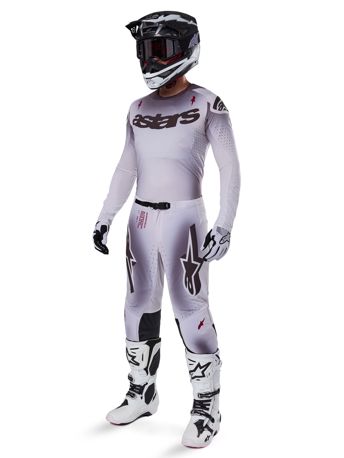 Motocross rider wearing 2025 Supertech Maker Pants in Silver Black, coordinated with a matching silver and grey jersey, black and white helmet, and white racing boots, featuring technical athletic fit for professional off-road performance.