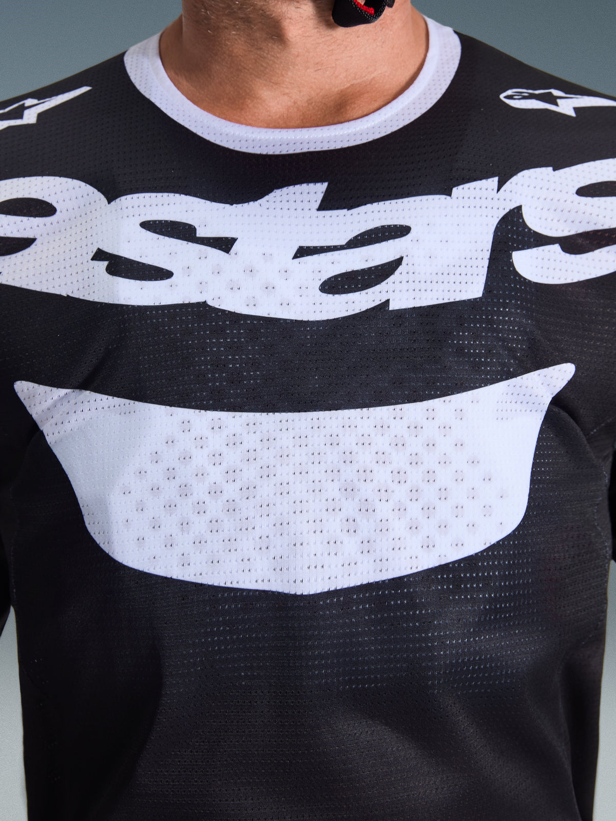 Alpinestars 2026 Racer Air Riway Jersey, Motocross-Trikot, Schwarz und Weiß, Nahaufnahme des Brustbereichs mit großer weißer Grafik und atmungsaktiver Mesh-Konstruktion, weißer Kragen und Logos an den Schultern