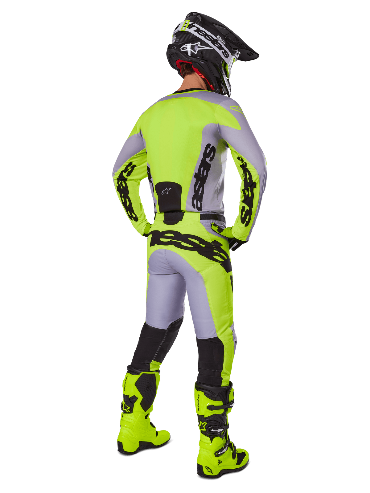 Motocross-Fahrer von hinten im Alpinestars 2025 Racer Veil Gear Set, Trikot und Hose in Grau und Gelb Fluo, passende fluorgelbe Stiefel und schwarz-gelber Helm, koordinierte Ausrüstung für den Offroad-Rennsport