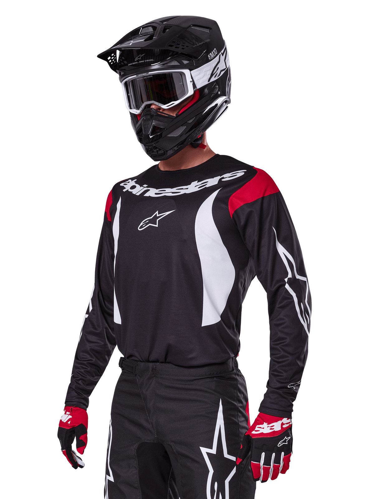 Motocross-Fahrer im Alpinestars 2025 Fluid Haul Ausrüstungsset, schwarzes Trikot mit roten Schultereinsätzen und weißen Grafiken, passende schwarze Hose mit weißen Stern-Logos, rote und schwarze Handschuhe, schwarzer Helm mit weißen Akzenten und Schutzbrille, abgestimmte Motocross-Bekleidung.