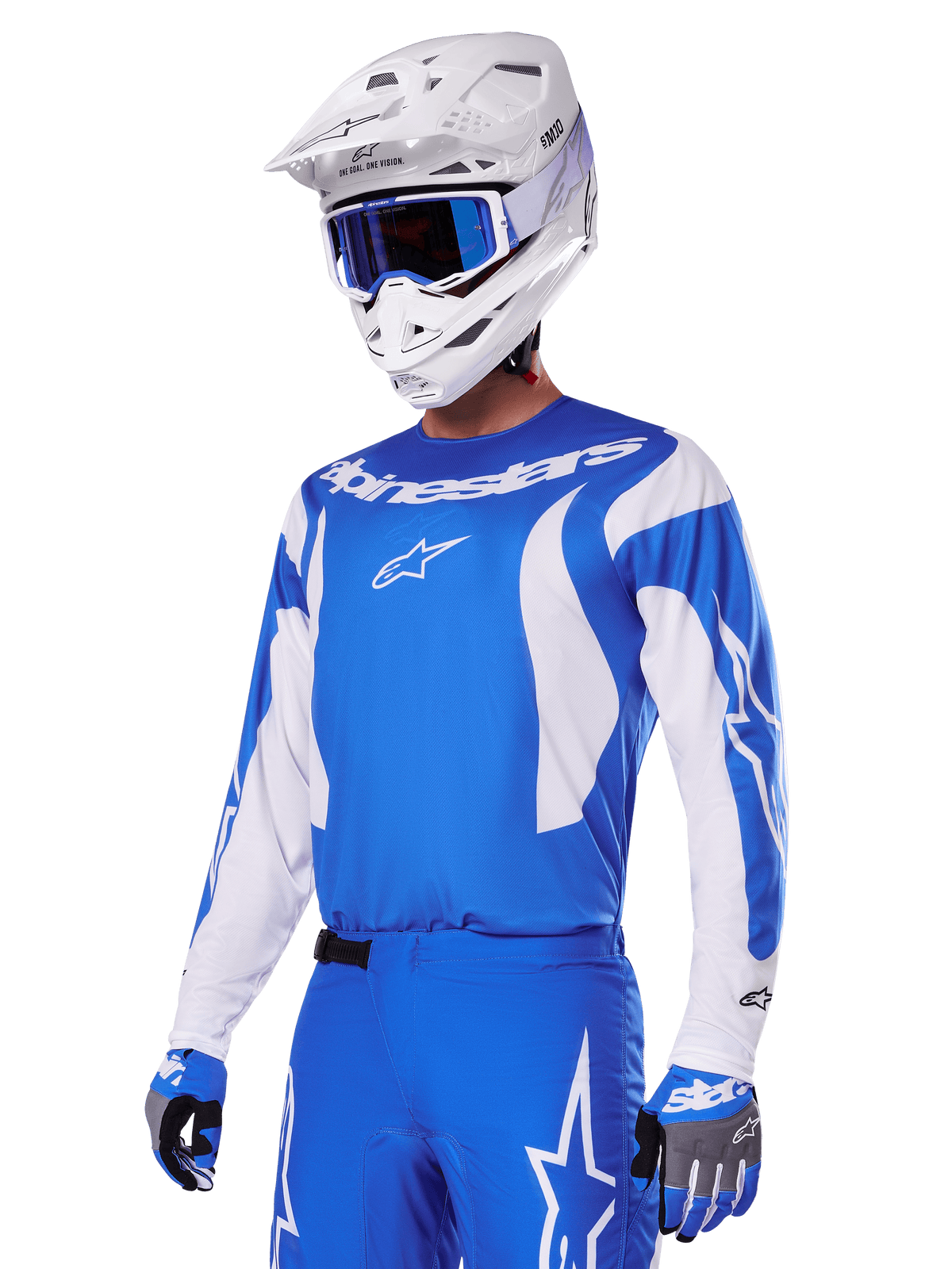 Motocross-Fahrer im Alpinestars 2025 Fluid Haul Gear Set in Blau und Weiß, bestehend aus einem blauen Jersey mit weißen Akzenten, passender blauer Hose mit Stern-Logos, weißem Helm mit blauer Goggle und abgestimmten blau-grauen Handschuhen, komplette Offroad-Rennausrüstung.