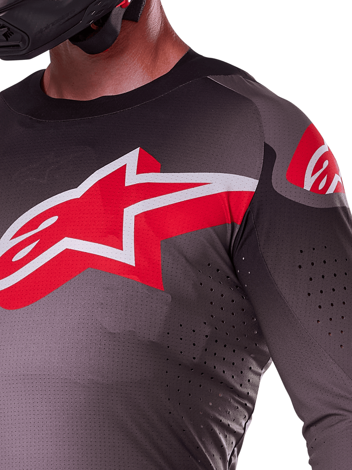Alpinestars 2025 Supertech Lipan Jersey, Smoke Bright Red, close-up view showing the large red and white star logo on the chest, laser-cut perforations for airflow, and lightweight breathable fabric on a rider.