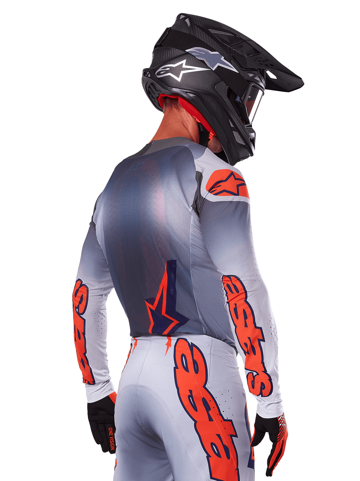 Motocross-Fahrer von hinten im Alpinestars 2025 Supertech Lipan Jersey in Grau Orange Fluo, mit markanten orangefarbenen Logos auf den Ärmeln und dem Rücken, kombiniert mit passender Hose und schwarzem Helm, professionelles Rennoutfit für Offroad-Performance.