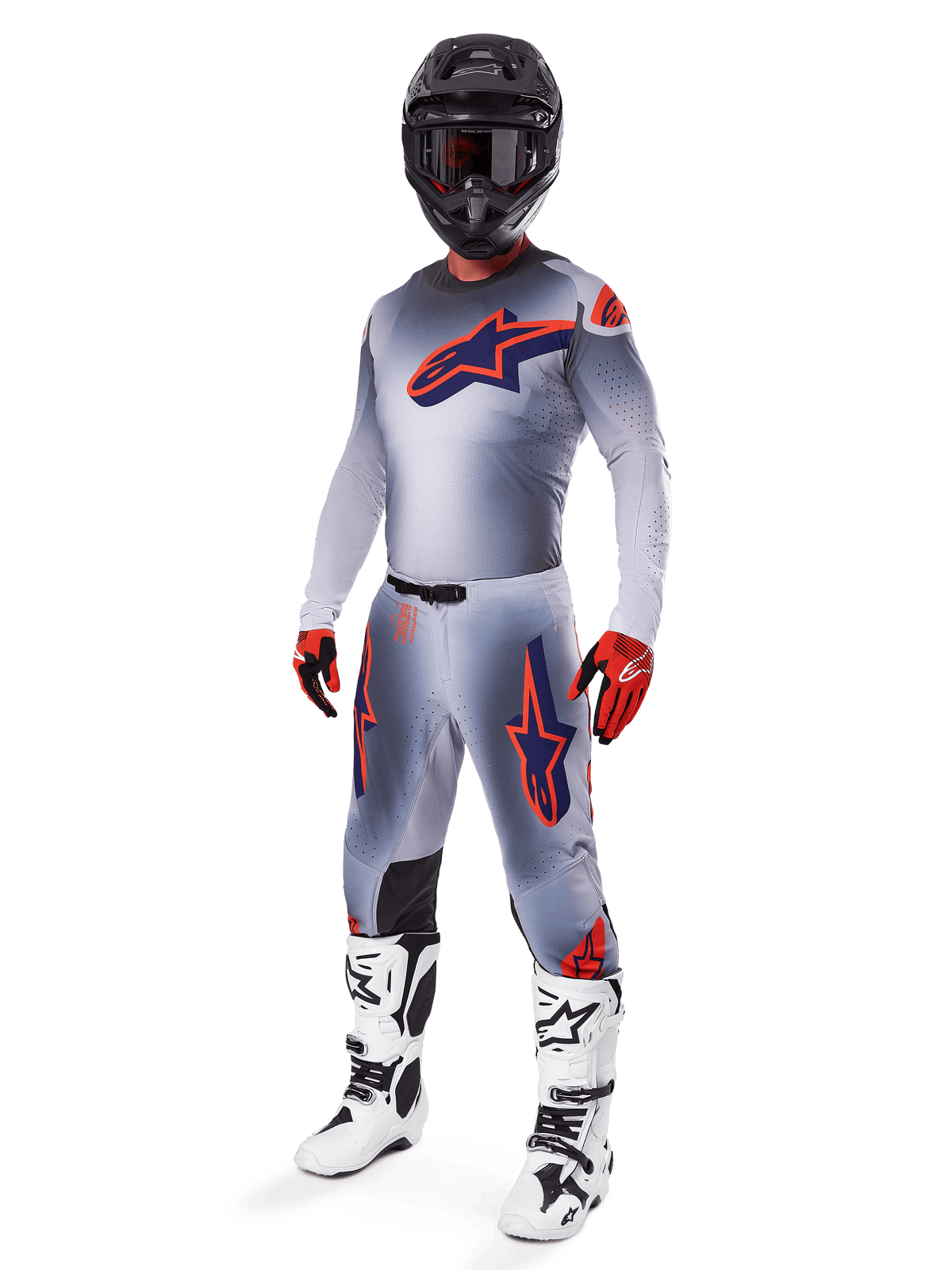 Motocross-Fahrer im Alpinestars 2025 Supertech Lipan Jersey in Grau und Orange Fluo, passende graue Hose mit orangefarbenen Akzenten, schwarzer Helm, weiß-schwarze Stiefel und orange-schwarze Handschuhe, professionelles Ausrüstungsset für Offroad-Rennen