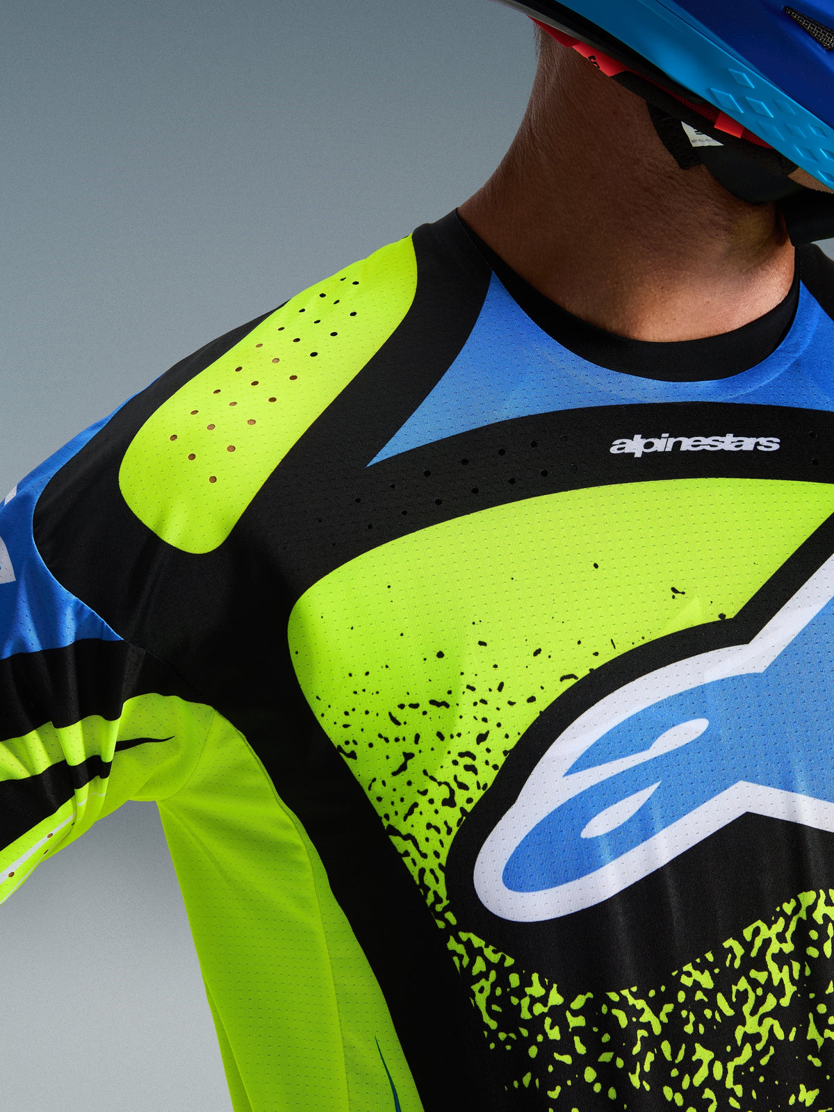 Alpinestars 2026 Techstar Nomur Jersey, Motocross Jersey, Yellow Fluo, Dark Navy and UCLA Blue, close-up view of the chest and shoulder showing laser-cut perforations for ventilation and the Alpinestars logo, performance off-road racing gear