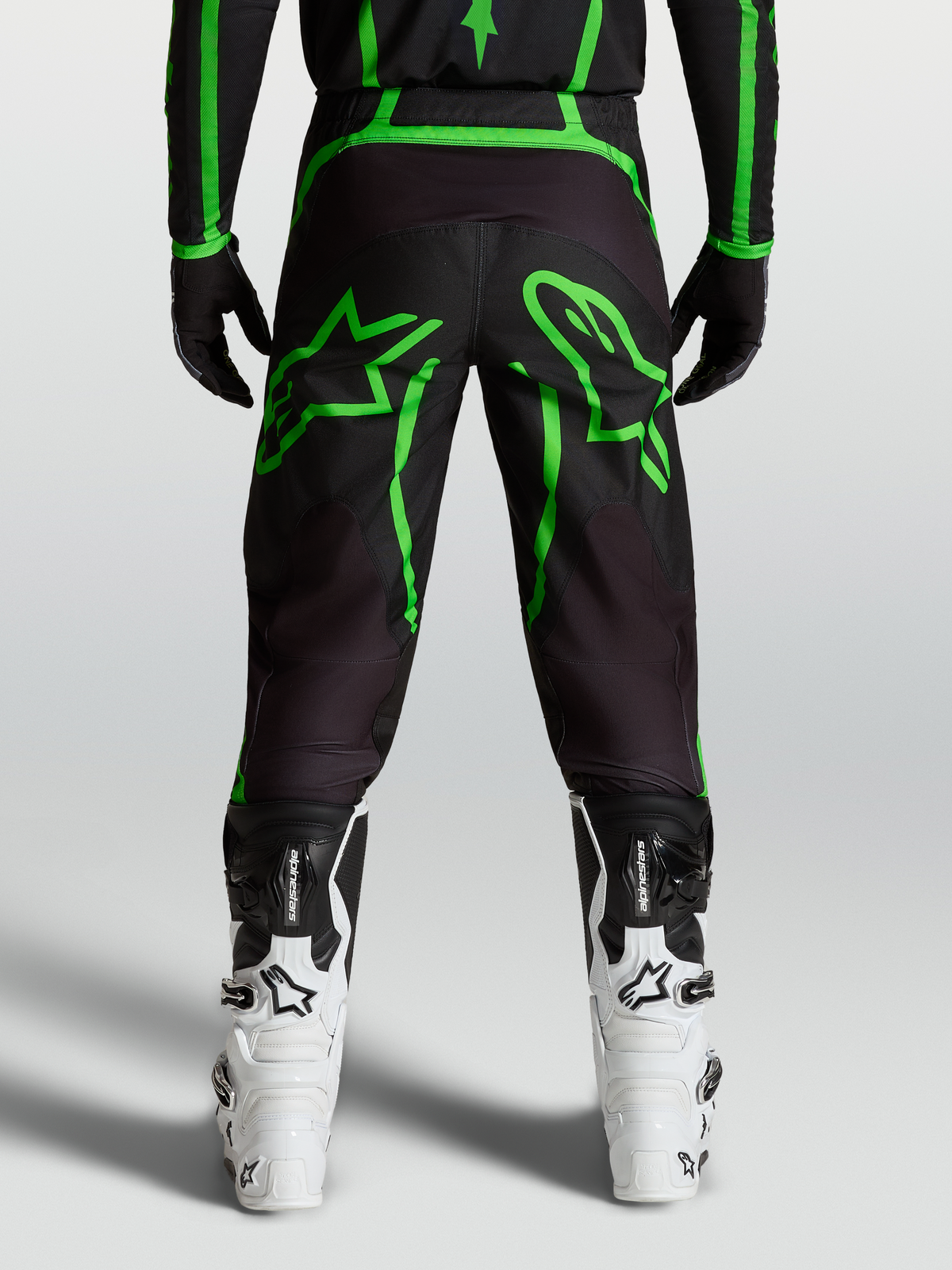 Alpinestars Fluid Apex V2 Hose, Motocross-Hose für Herren, Schwarz und Fluo-Grün, Rückansicht am Model mit großen Stern-Grafiken