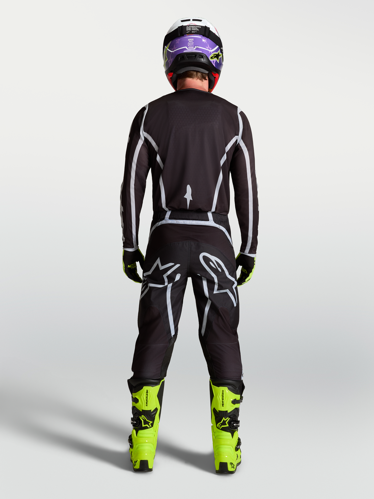 Alpinestars Fluid Apex V2 Trikot, Motocross-Ausrüstung für Herren, Schwarz und Silber, Rückansicht am Fahrer in kompletter Rennausrüstung.